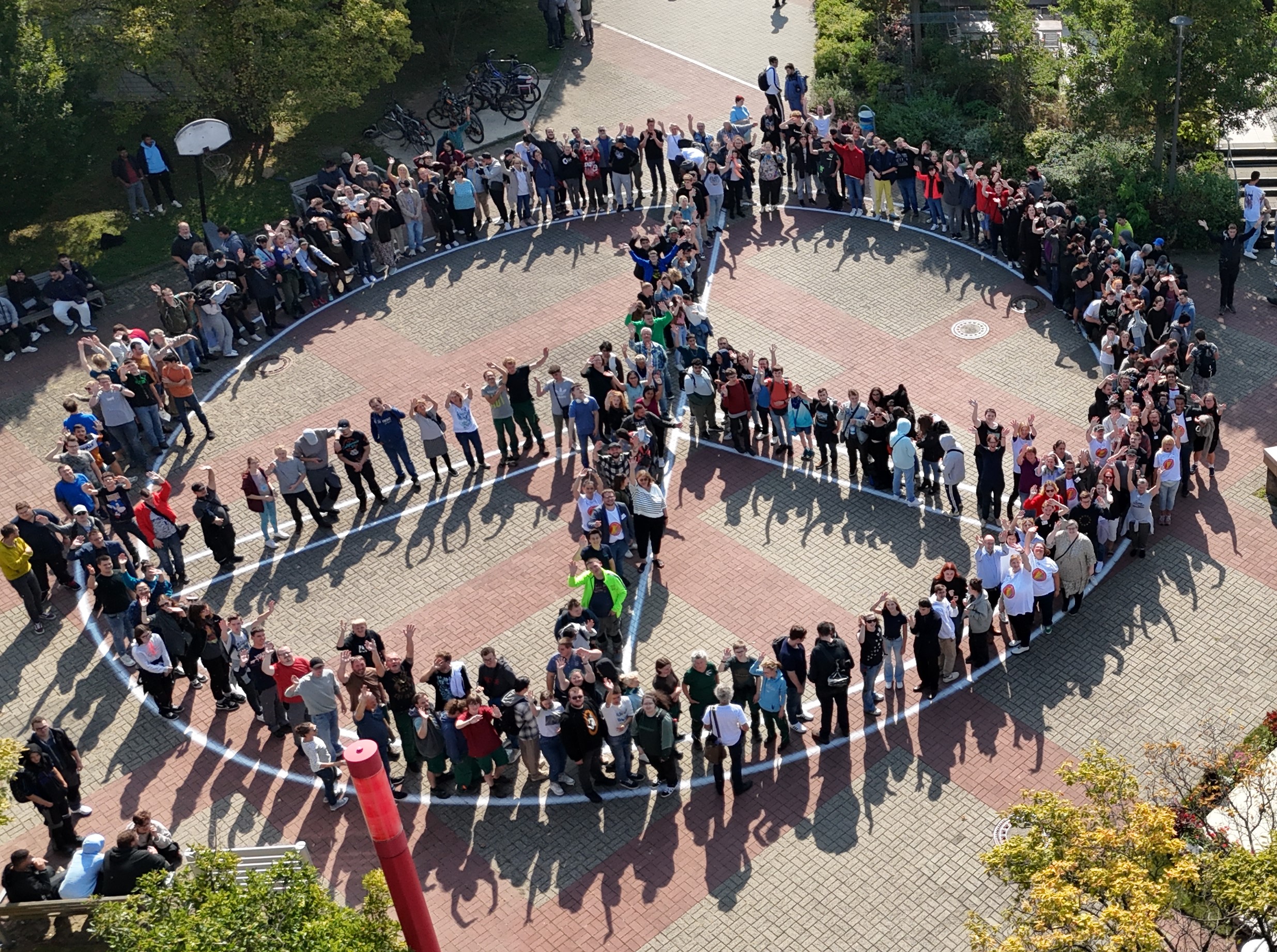 Teilnehmende und Mitarbeitende stellen ein Peace-Zeichen